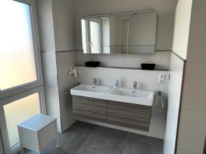 une salle de bain avec un lavabo et un miroir dans l'établissement Nordsee Park Haus Friesland 7 P113, à Dangast 12 autres photos