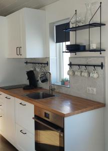 uma cozinha com um lavatório e uma bancada de madeira em Tungukot sumarhús em Akureyri
