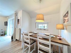 a kitchen and dining room with a table and chairs at Haus Auszeit, Bordumer Str 16A, 70qm in Dangast