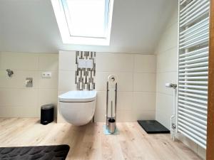 a bathroom with a toilet and a skylight at Haus Auszeit, Bordumer Str 16A, 70qm in Dangast +16 photos