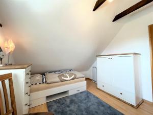 a bedroom with a bed and a dresser in a attic at Haus Auszeit, Bordumer Str 16A, 70qm in Dangast