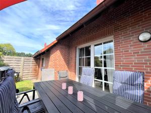 a wooden table with four pink cups on a patio at Haus Auszeit, Bordumer Str 16A, 70qm in Dangast