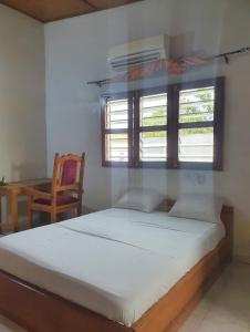 um quarto com uma cama, uma mesa e uma janela em Delalie Hotel em Palimé