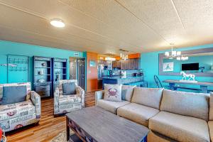 a living room with a couch and a kitchen at Assateague House 205 in Ocean City