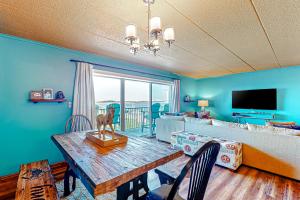 a living room with a table and a couch at Assateague House 205 in Ocean City