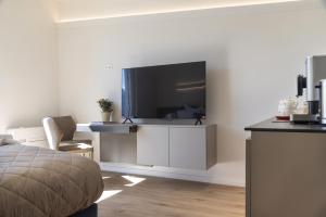 una camera da letto con TV a schermo piatto a parete di Lake Dream a Brissago