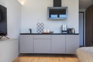 a kitchen with white cabinets and a microwave at Lake Dream in Brissago