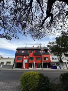 un edificio rojo al lado de una calle en Hotel Posada Jardín Aguascalientes, en Aguascalientes