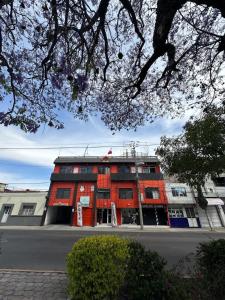 un bâtiment rouge sur le côté d'une rue dans l'établissement Hotel Posada Jardín Aguascalientes, à Aguascalientes