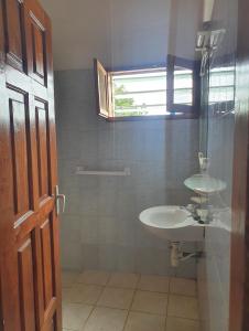 W łazience znajduje się umywalka i przeszklony prysznic. w obiekcie Delalie Hotel w mieście Kpalimé