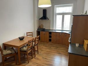 uma cozinha com uma mesa de madeira e cadeiras de madeira em Apartmán Teplice em Teplice