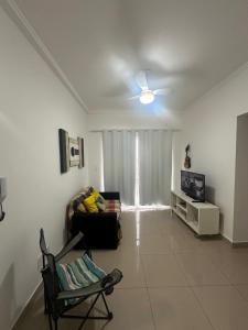 - un salon avec un canapé et une télévision dans l'établissement Apto Apólo - 3 dorm Wifi, à São Carlos