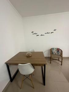 Apto Apólo - 3 dorm Wifi في ساو كارلوس: طاولة خشبية وكرسي في الغرفة