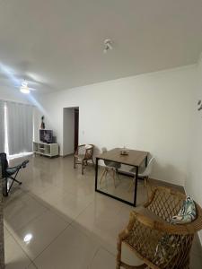 een woonkamer met een tafel en stoelen bij Apto Apólo - 3 dorm Wifi in São Carlos