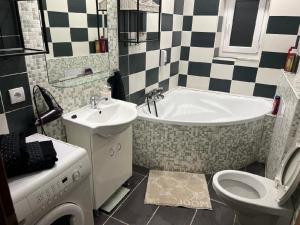 uma casa de banho com uma banheira, um lavatório e um WC. em Apartmán Teplice em Teplice