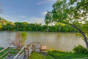 a dock with two benches next to a river at Rustic River Cabin with Dock and Covered Deck! in Waco