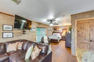 韋科的住宿－Rustic River Cabin with Dock and Covered Deck!，客厅配有真皮沙发和床。