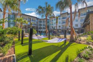 a hammock in front of a building with palm trees at RISE Bartram Park Condos by Barsala in Jacksonville