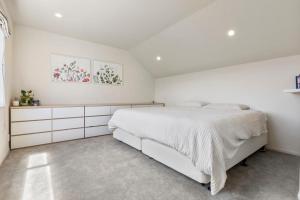 een witte slaapkamer met een groot wit bed. bij Modern Sanctuary on the reserve in Auckland