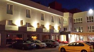 Hotel Sierra Las Villas في فياكاريو: مبنى ابيض كبير فيه سيارات تقف امامه
