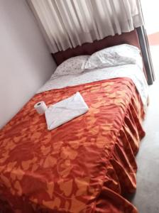 Una cama con dos toallas blancas encima. en Descanso de Vallecito, en Hacienda Huampani