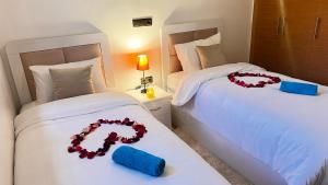 - une chambre avec 2 lits avec des roses dans l'établissement mini-villa situee dans une residence Prestigia à Marrakech, avec une vue sur la piscine et le golf une securite 24h sur 24 et une proximite ideale de l aeroport 5 minutes C est une offre parfaite pour des vacances, à Marrakech 40 autres photos