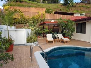 a backyard with a pool and a table and chairs at Villas TEAKEVEHERE - Fare OPUHI in Pirae