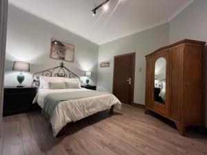 Hotel Casa Aure في سانتياغو: غرفة نوم بسرير وخزانة ومرآة
