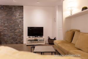 ein Wohnzimmer mit einem Sofa und einem Flachbild-TV in der Unterkunft Appartamento Bianca in Bellagio