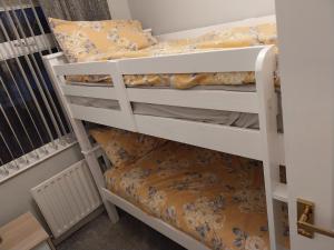 Etagenbett in einem kleinen Zimmer mit Etagenbett in einem Schlafzimmer. in der Unterkunft 3 bedroom house in portrush in Portrush