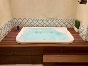 a jacuzzi tub in a bathroom with a wooden floor at Loft Mueganos III en Val´Quirico in Santeagueda