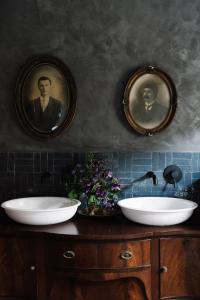 a bathroom with two sinks and two portraits on the wall at Ethelmont Rise in Sandy Bay