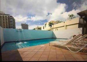 a swimming pool with chairs and a fountain on a building at Condado Oasis on Ashford ave: OceanView and Pool in San Juan