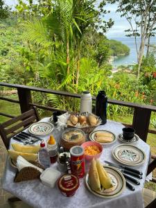 stół z jedzeniem na górze z widokiem na ocean w obiekcie Chalés da Longa w mieście Angra dos Reis