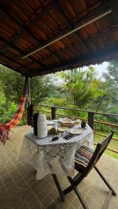 een tafel en stoelen op een veranda met een tafel bij Chalés da Longa in Angra dos Reis