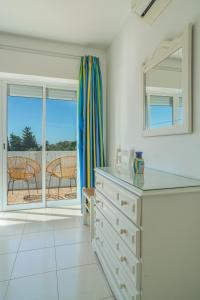 a white kitchen with a view of a patio at Casas do Ramalhete in Luz
