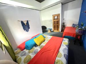 1 Schlafzimmer mit 2 Betten und bunter Bettwäsche in der Unterkunft Cheap Hostel Quepos in Quepos