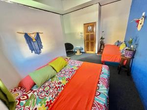 a bedroom with a bed with a colorful blanket at Cheap Hostel Quepos in Quepos