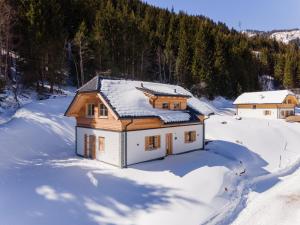 uma casa coberta de neve com árvores ao fundo em Wanderlust em Donnersbachwald