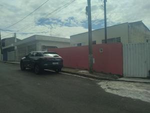 ein schwarzes Auto neben einem roten Zaun geparkt in der Unterkunft Casa Bela Vista in Socorro