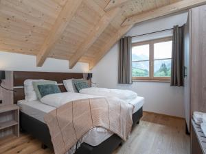 two beds in a bedroom with a wooden ceiling at Haus Liene in Donnersbachwald