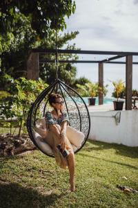 a woman is sitting in a swing at South Pacific Memories in Port Vila