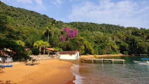 a house on a beach next to a body of water at Chalés da Longa in Angra dos Reis