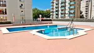a swimming pool in the middle of a building at REYNA Playa de Gandía - Alquiler solo a familias in Los Mártires