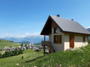 a house on a hill with mountains in the background at Chalet Albiez-Montrond, 4 pièces, 8 personnes - FR-1-618-16 in Albiez-Montrond
