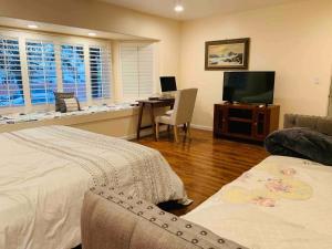 Dormitorio con cama, escritorio y TV en Spacious & Pet Friendly Oceanside Home en Oceanside
