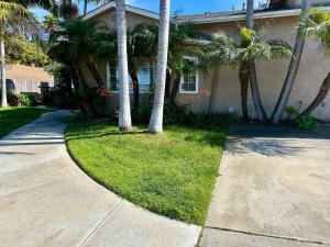 a house with palm trees next to a driveway at Spacious & Pet Friendly Oceanside Home in Oceanside
