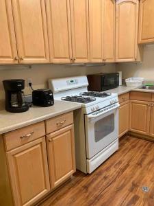 a kitchen with a white stove and wooden cabinets at Spacious & Pet Friendly Oceanside Home in Oceanside