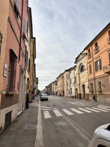 um carro estacionado ao lado de uma rua com edifícios em Il loft di charme di Ricc em Faenza