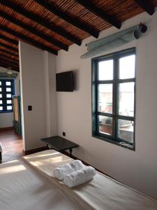 1 dormitorio con 1 cama con 2 toallas en Casa Silva - Hotel Cafe en Curití